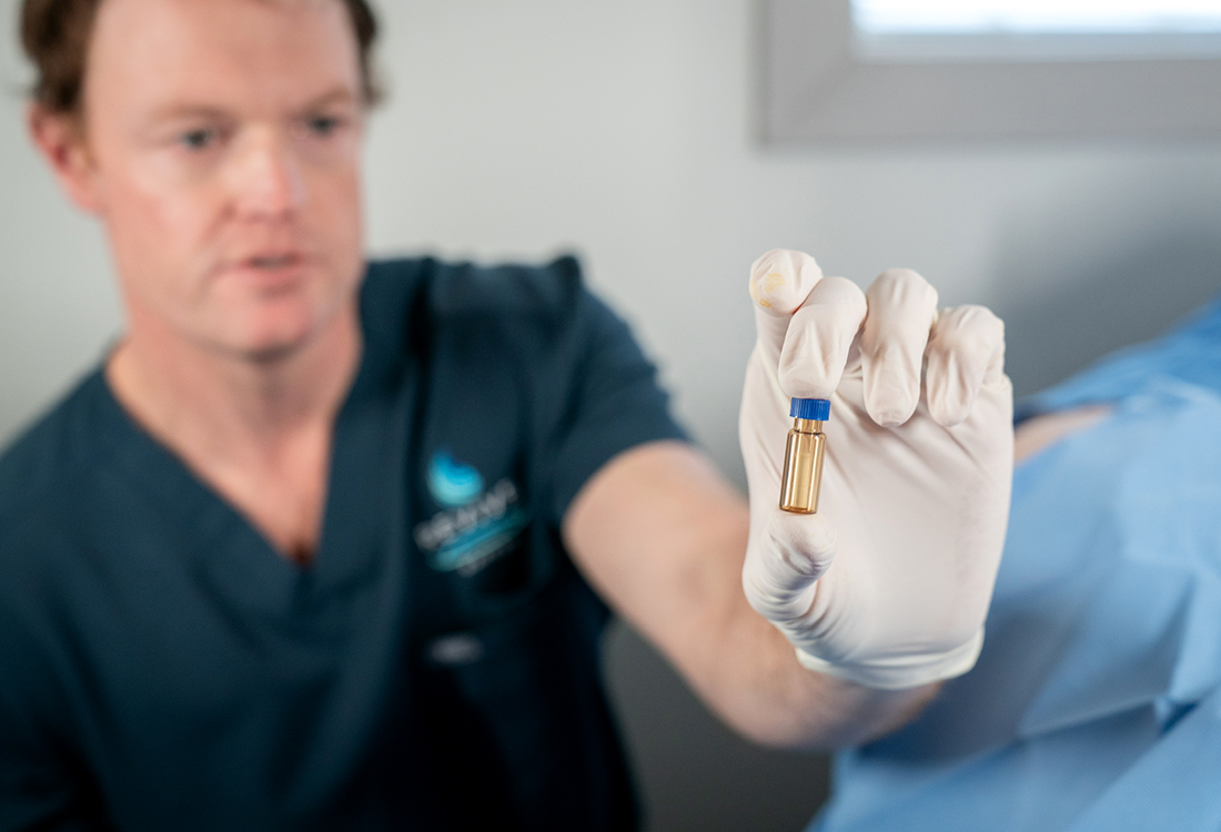 Dr. Joshua Griffin holds up a hormone pellet
